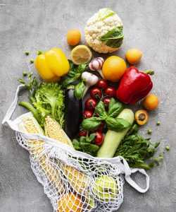 Fresh vegetables and fruits on eco string bag on a concrete back